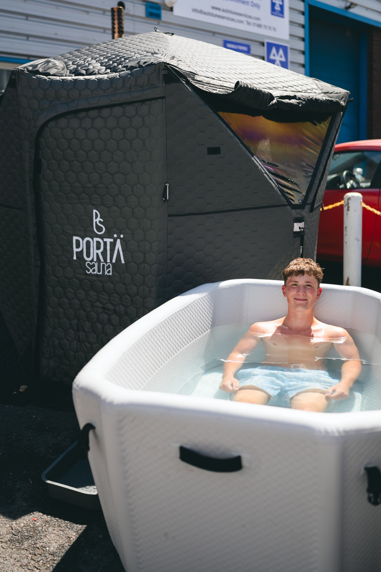 Man in a cold plunge next to the sauna at a NERVA pop-up in Hampshire